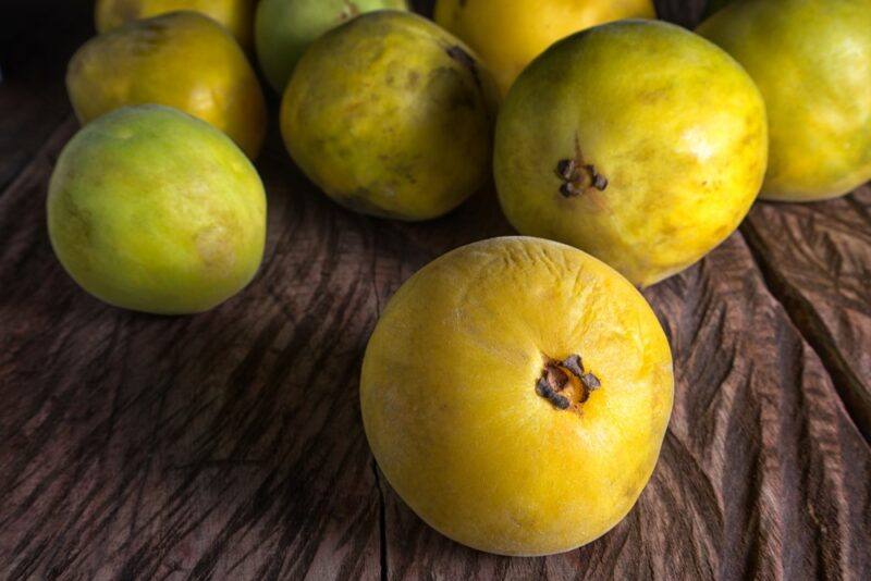 A wooden table with round green yellow araza fruit