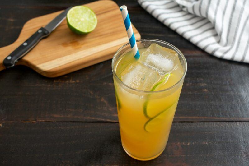 A wooden table with tra chanh, a type of iced Vietnamese tea. There's a wooden board in the background with a knife