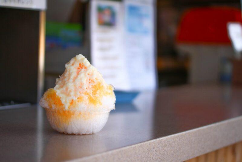 A counter with a single dish containing a pina colada snow cone