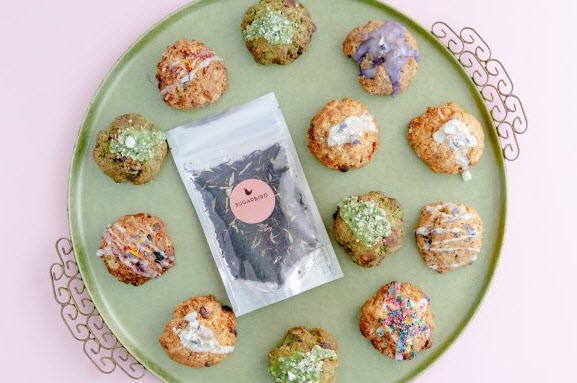 A green tray with scones and a bag of tea