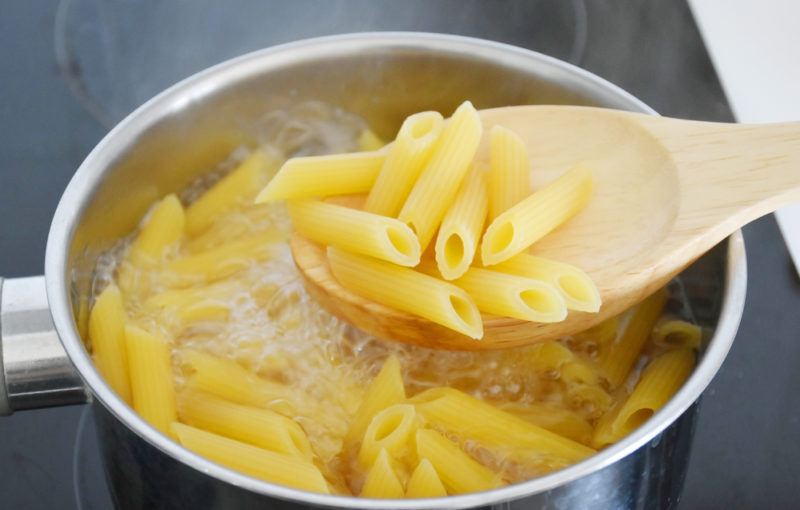 Al dente pasta in a pot with a spoon