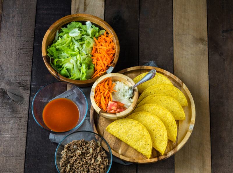 Multiple dishes with the ingredients to make homemade tacos