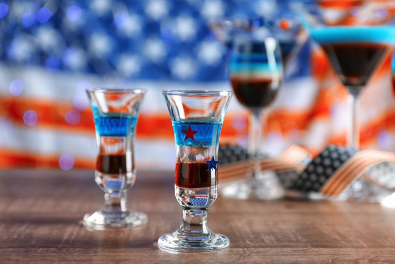 Two shot glasses and two other glasses with an American flag cocktail