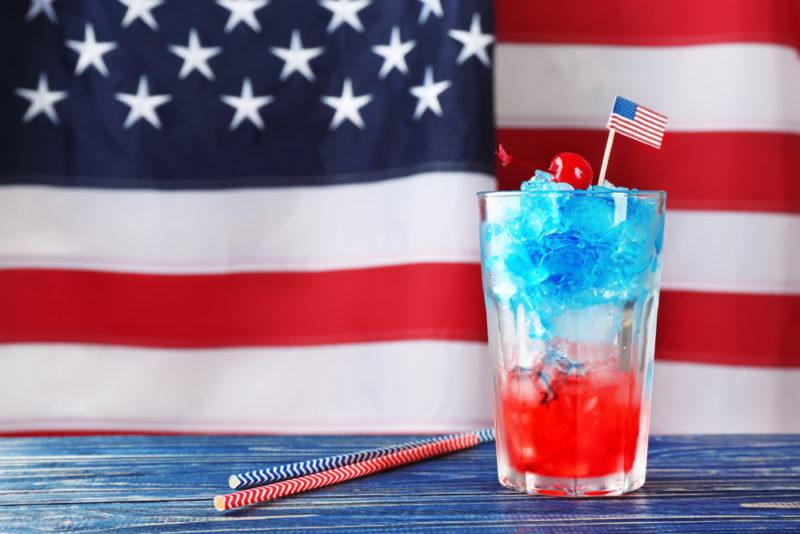 An American flag cocktail with a fully American flag in the background