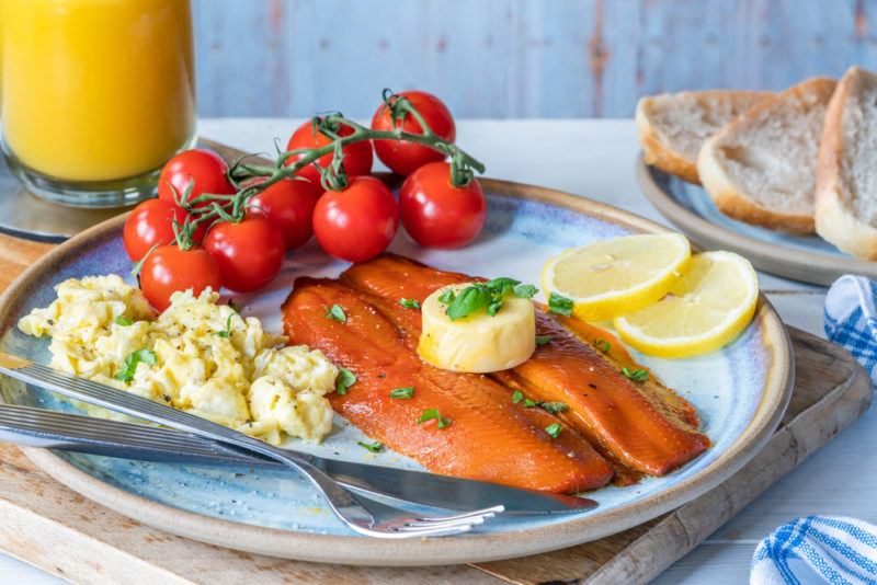 An English breakfast with kippers, eggs, tomoatos, lemons, butter and orange juice