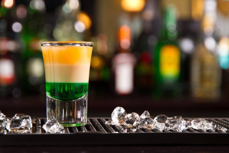 A three-layer Irish flag shot with an out-of-focus bar in the background