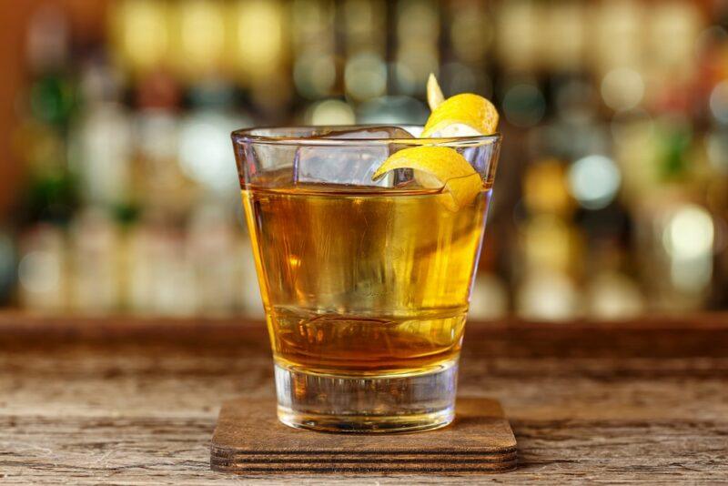 A glass containing an Angry Badger shot on a bar, with out of focus bottles in the background