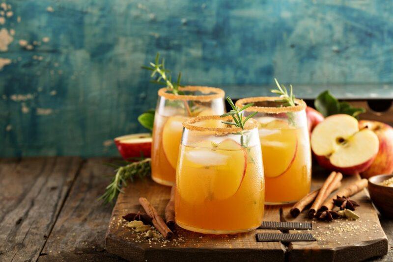 Three rimmed glasses of apple cider or an apple cider cocktail