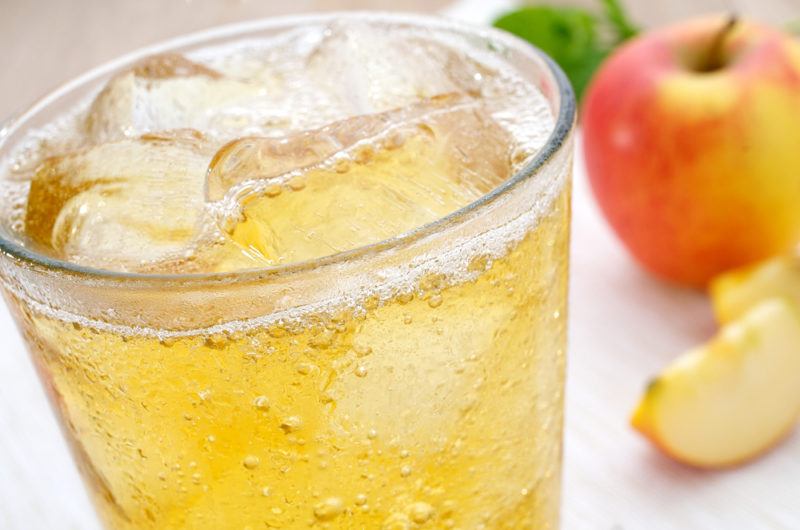 A glass of apple spritzer with ice