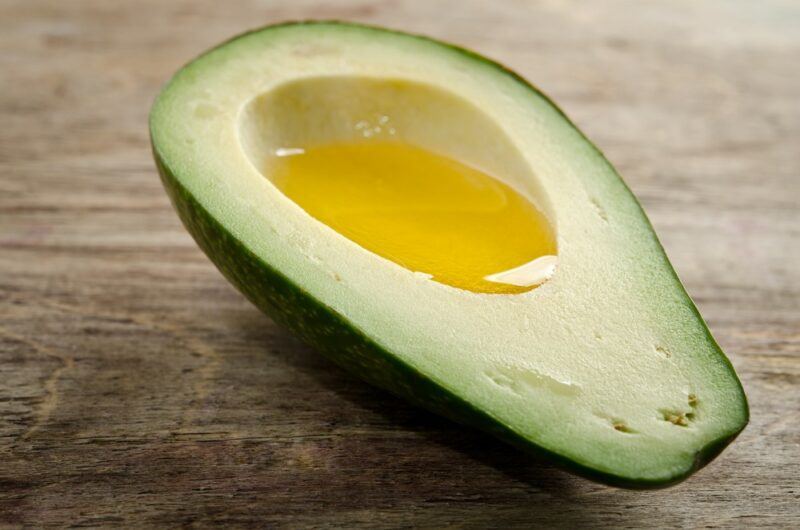 Half an avocado that has been filled with avocado oil