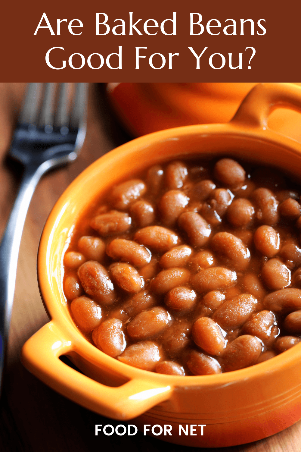 Are Baked Beans Good For You? A yellow dish filled with baked beans, next to a fork