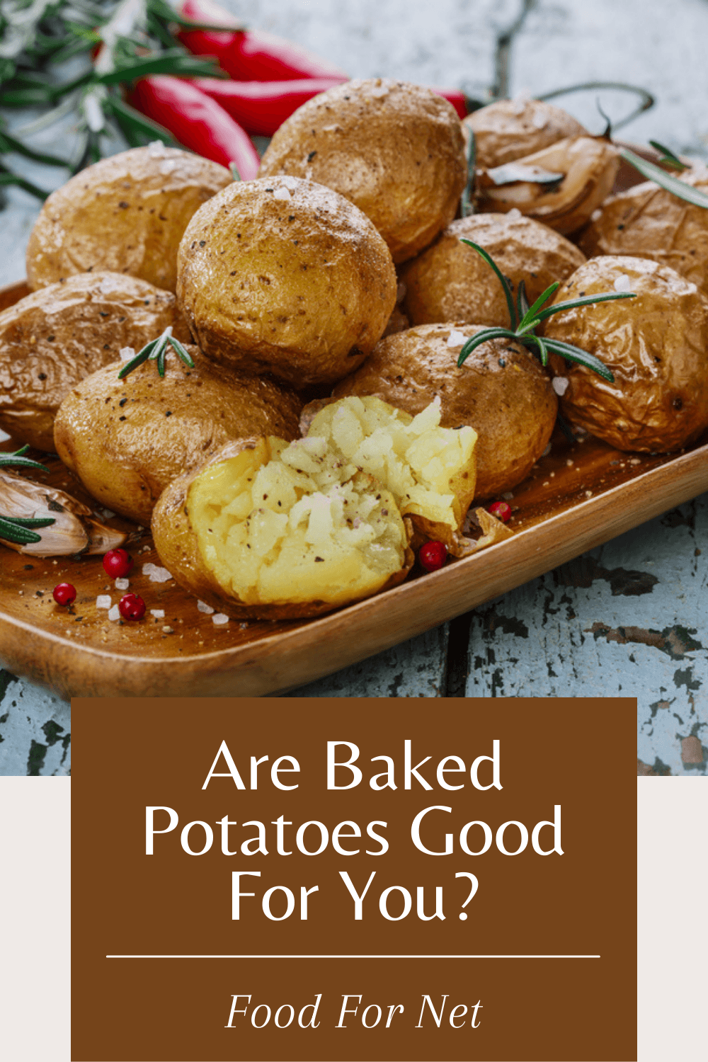 A wooden tray containing small baked potatoes, looking at whether baked potatoes are good for you