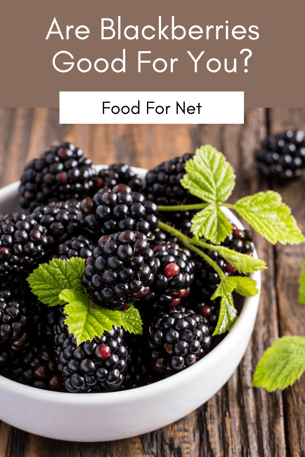 A white bowl of blackberries on a wooden table, highlighting the question of whether blackberries are good for you