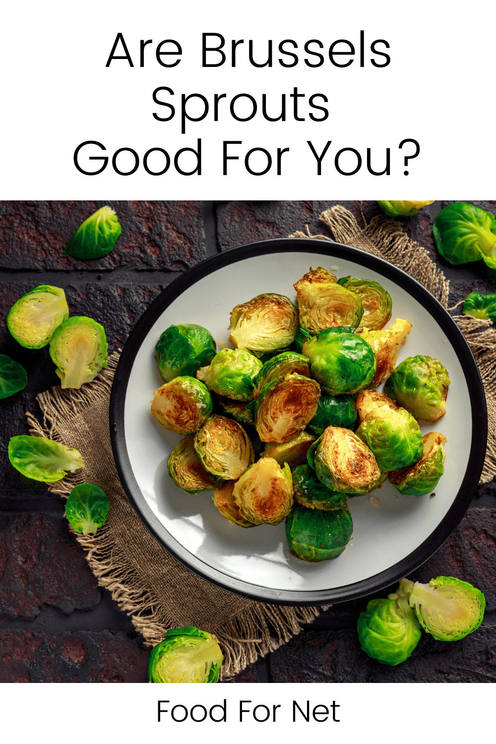 A white plate with grilled Brussels sprouts on a table with a few fresh Brussels sprouts scattered around, looking at whether the vegetables are good for you