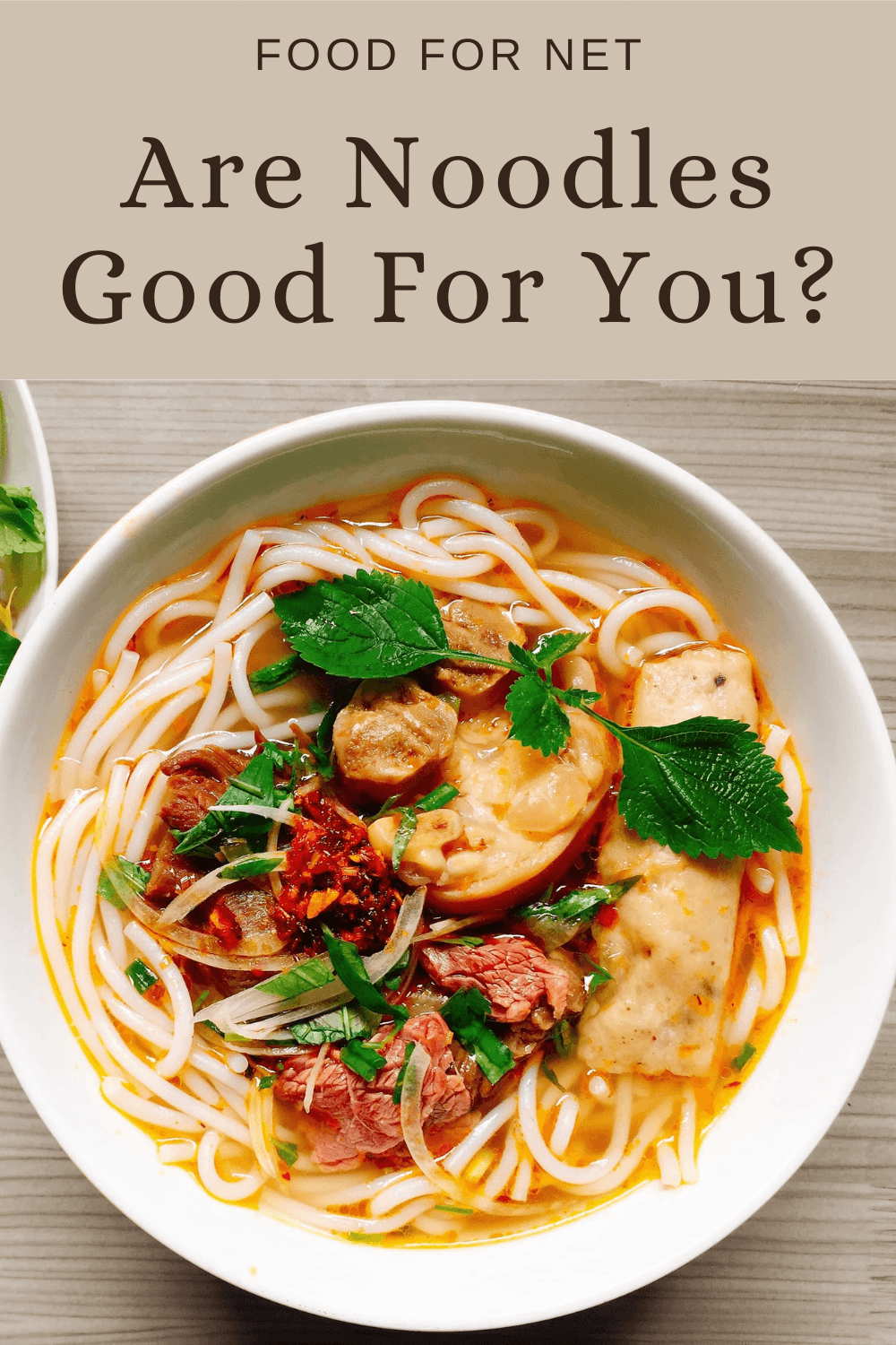 A white bowl filled with noodles, protein, and vegetables, looking at the question of whether noodles are good for you