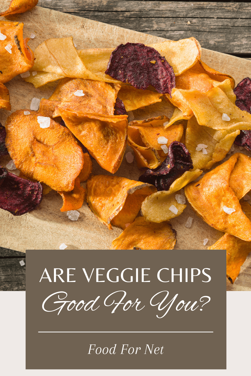 A wooden board with dehydrated salted veggie chips, looking at whether veggie chips are good for you