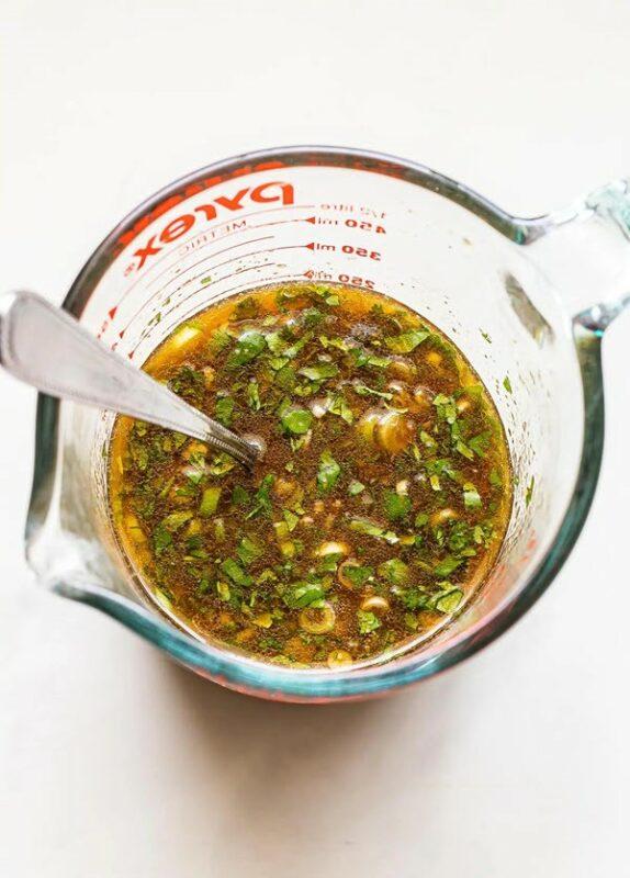 A glass bowl containing marinade for flank steak