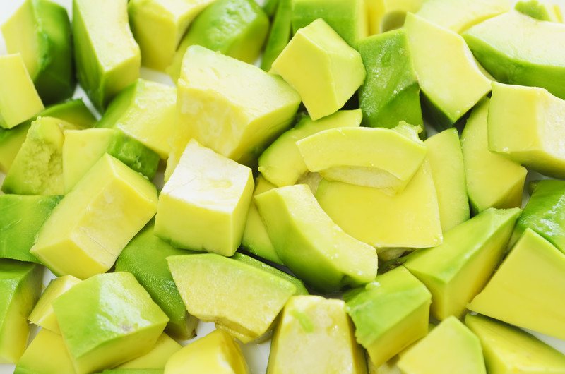 This photo shows a closeup of pale green peeled, chopped avocado pieces.