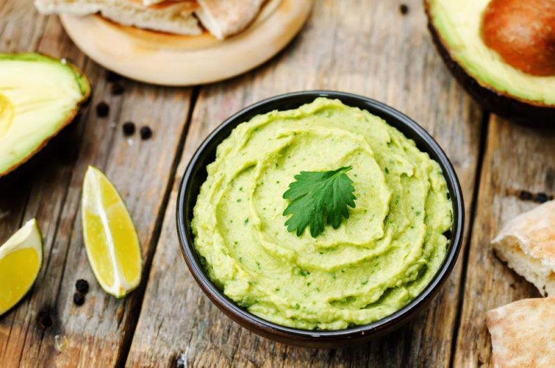 A black bowl containing avocado hummus