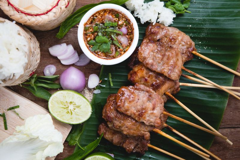 Thai BBQ meat on a stick next to seasonings