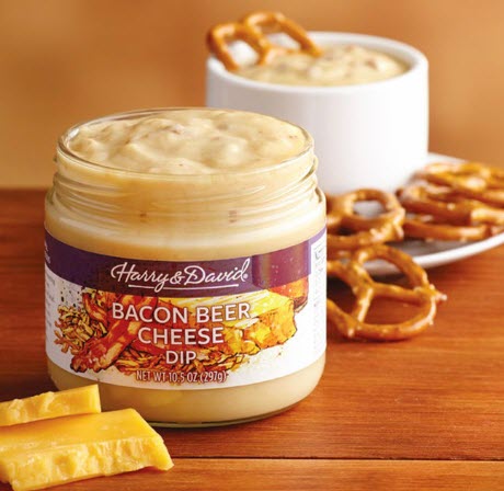 A glass jar of bacon beer cheese with pretzels