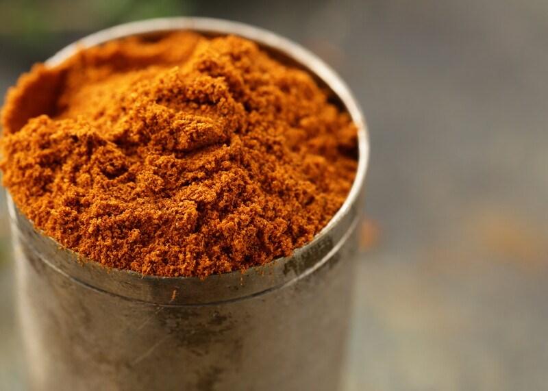 closeup image of a tin can full of baharat powder