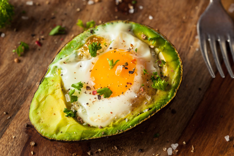 Half an avocado that has been baked with an egg inside