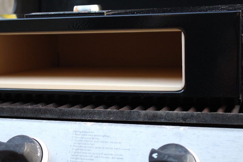 inside closeup image of clean bakerstone pizza box on top of gas grill