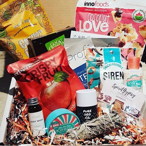 A collection of snacks and body products in a box