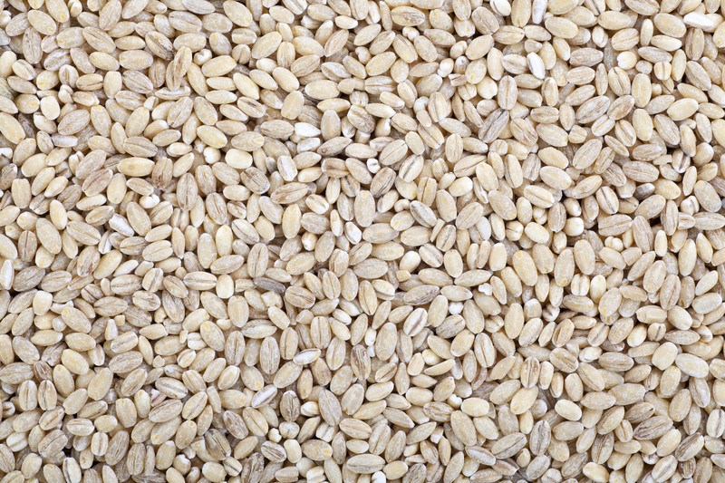 ThThis photo shows a closeup of several beige-colored grains of barley.