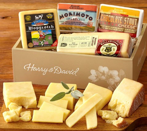 Box of cheese with cut cheese on a cheese board. 