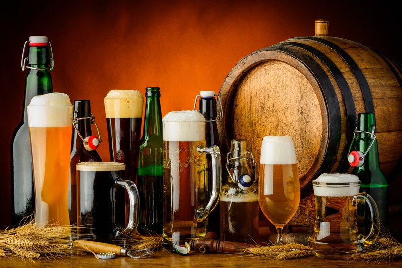 Selection of beer bottles and glasses with a beer barrel