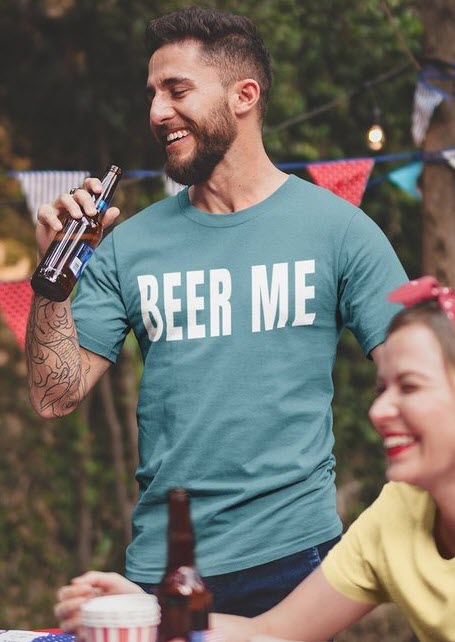 Image of a man drinking beer in a green/blue shirt that says 'Beer Me'