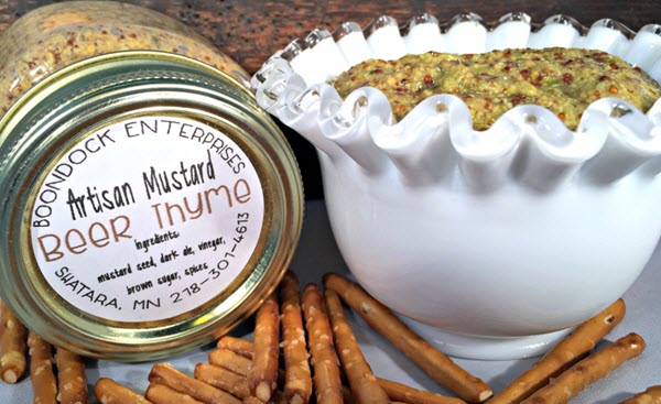 Bowl of mustard with a closed jar next to it. 