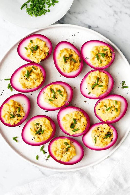 Beet pickled deviled eggs with pink exteriors and bright yellow interiors