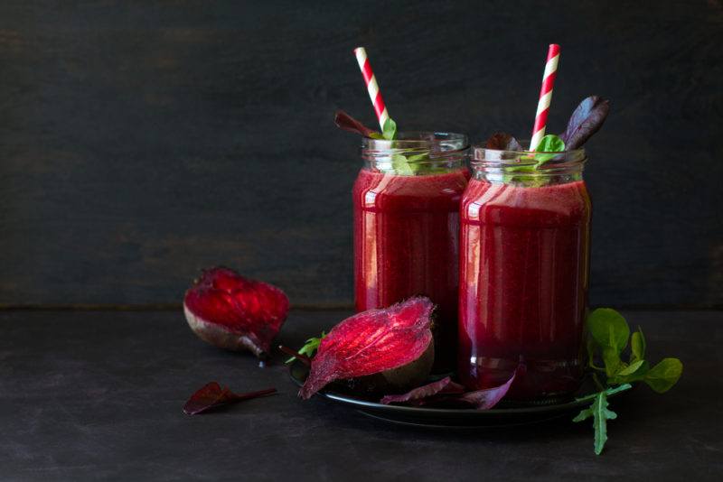 A sliced beetroot with two beetroot juices