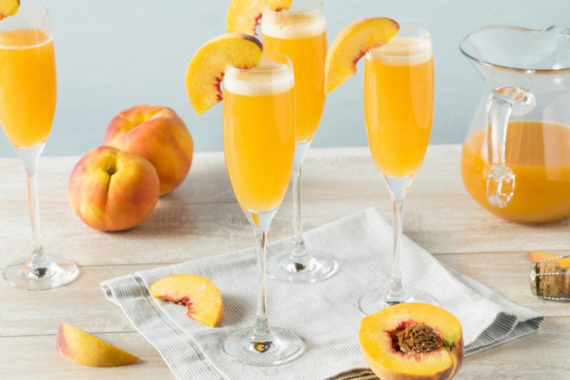 Various glasses of Bellini and peaches on the table