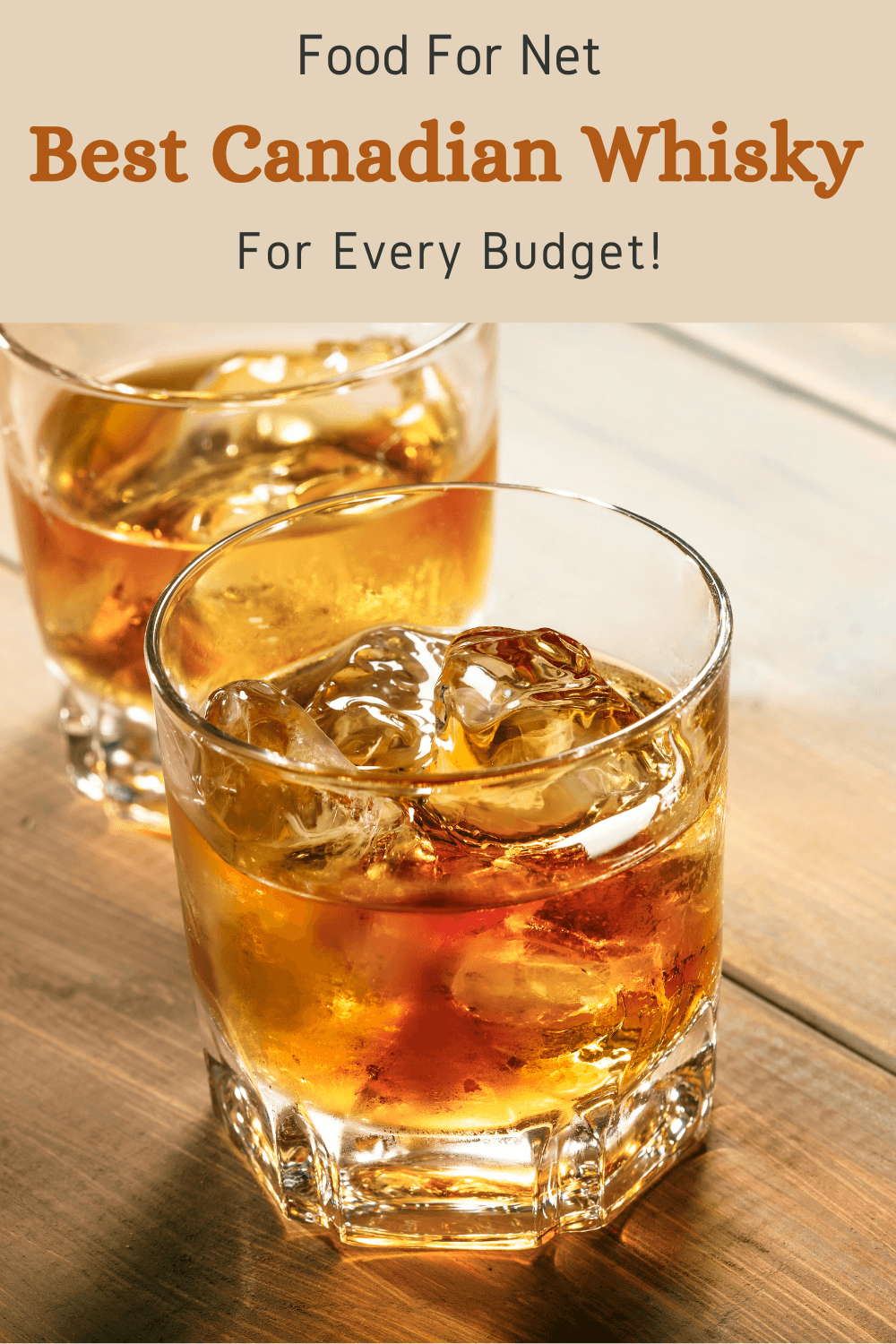 Two glasses of Canadian whisky on the rocks on a wooden table