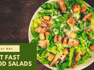 A lettuce and chicken salad on a white plate on a wooden table