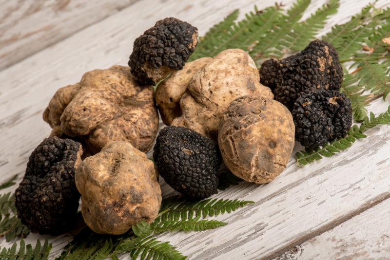 A wooden table with black and white truffles