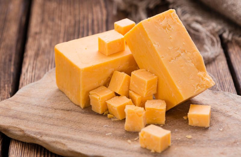 Blocks and squares of cheddar on a wooden board