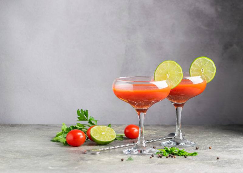 Two bloody Maria cocktails in glasses with sliced lime