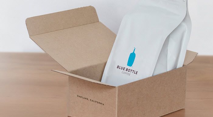 A cardboard box with a white bag of coffee from Blue Bottle coffee