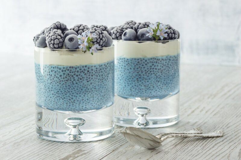 Two glasses of a chia spirulina pudding with yogurt and berries