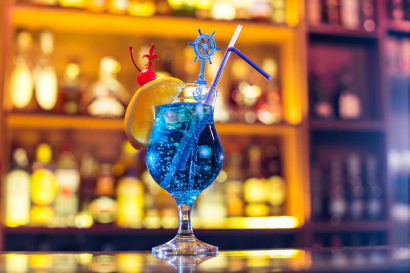 A blue lagoon cocktail in front of a bar