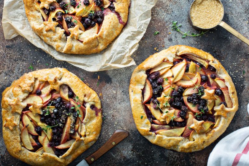 Three blueberry and peach pies on a table