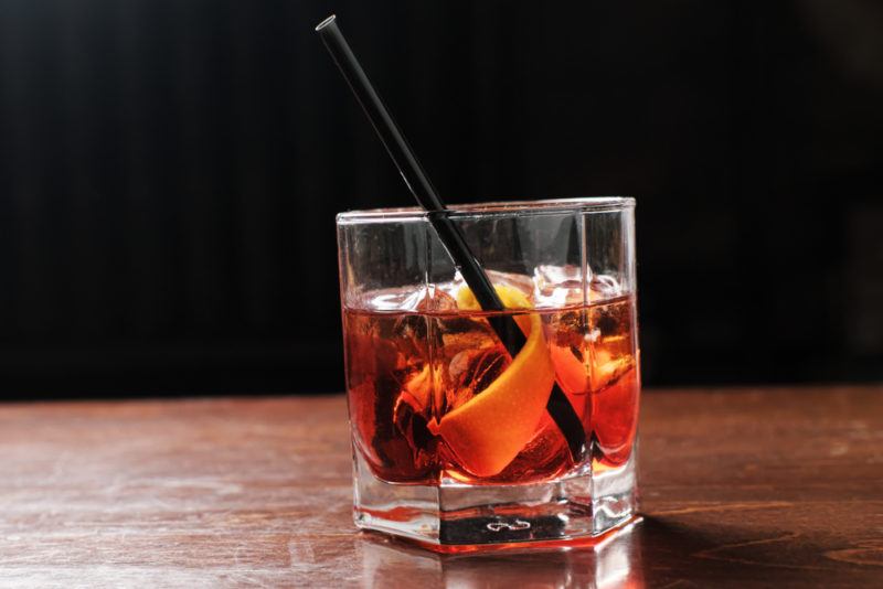 A Boulevardier cocktail with a straw in an old fashioned glass