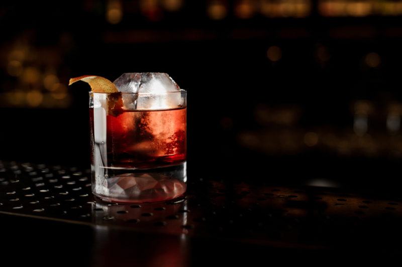 A Boulevardier cocktail on a black bar