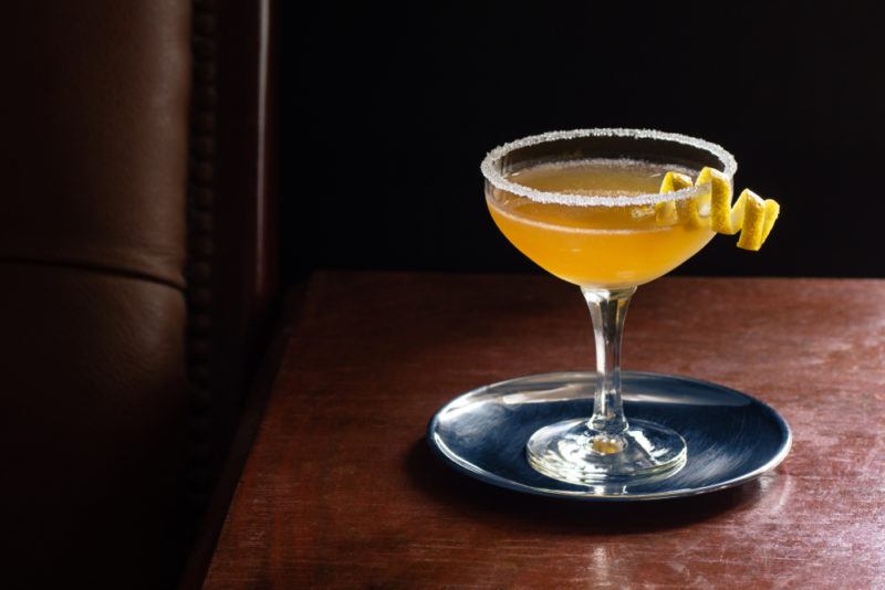 A bourbon sidecar cocktail in a cocktail glass on a small tray