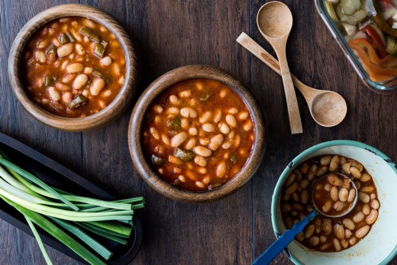 Three wooden bowls containing baked beans